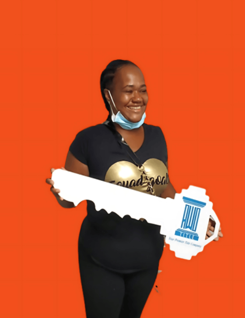 Sharron holding a sold sign